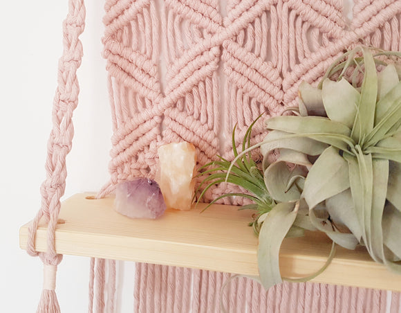 pink macrame shelf with air plant and crystals