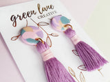 Pink and purple tassel earrings on backing card